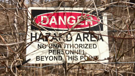 sign on fence indicates danger hazards area