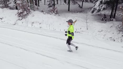 side view of woman running in winter forest