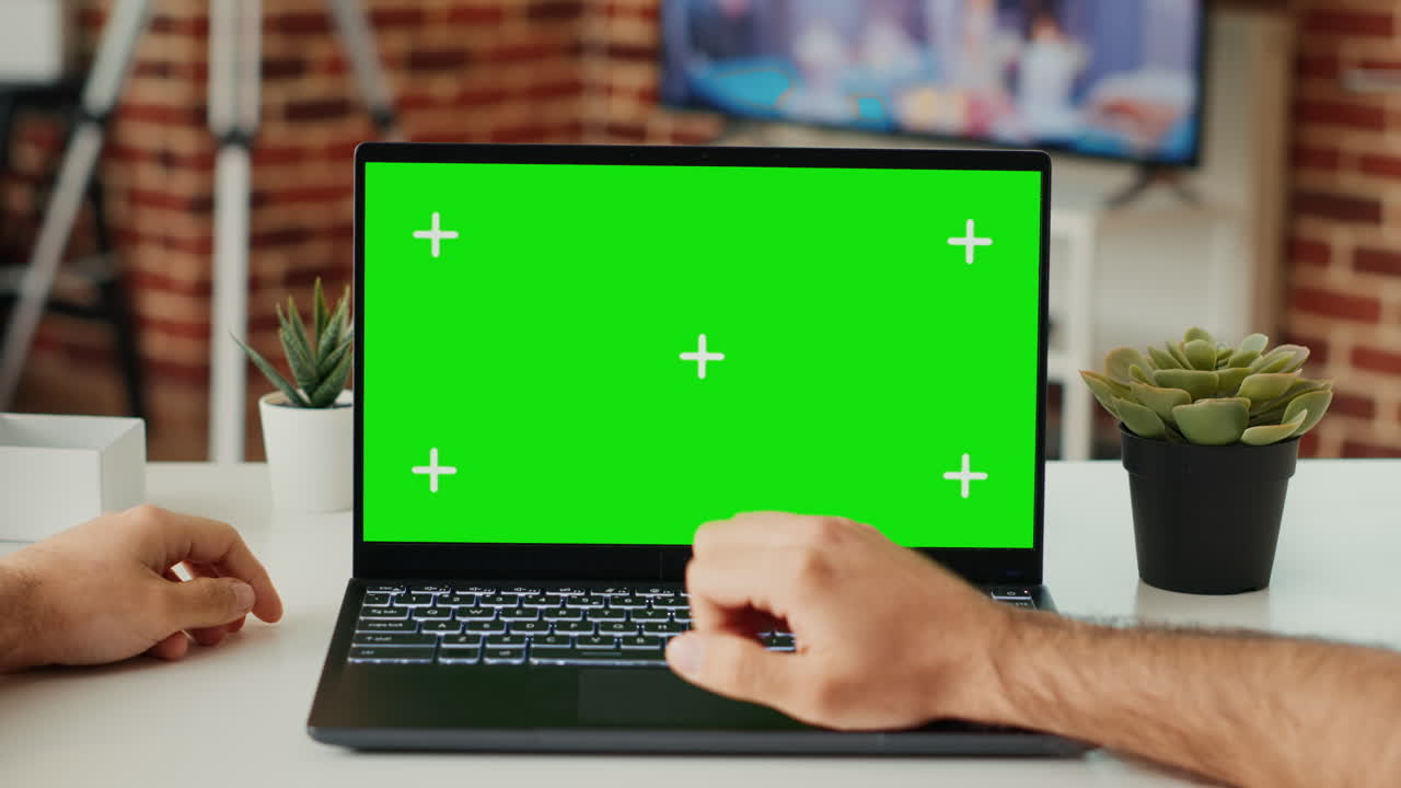 Male freelancer working on laptop with green screen template