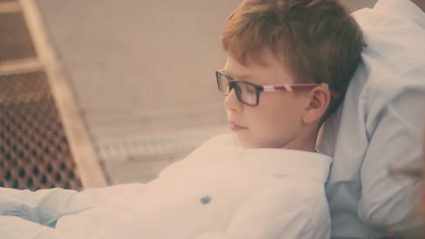 niño con gafas dibuja en un cuaderno de papel sosteniendo en la espalda de su compañero