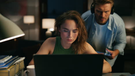 Focused-girl-reading-device-at-evening-closeup.-Lady-paying-no-attention-at-man