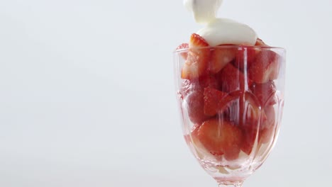 close-up of fresh strawberries with cream in glass