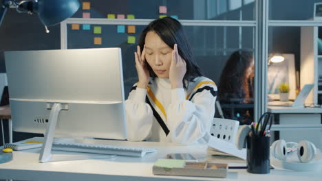 woman with headache at her desk
