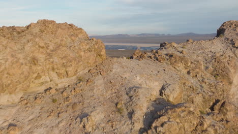 aerial revealing solar energy farm in the desert over rocky desert hills