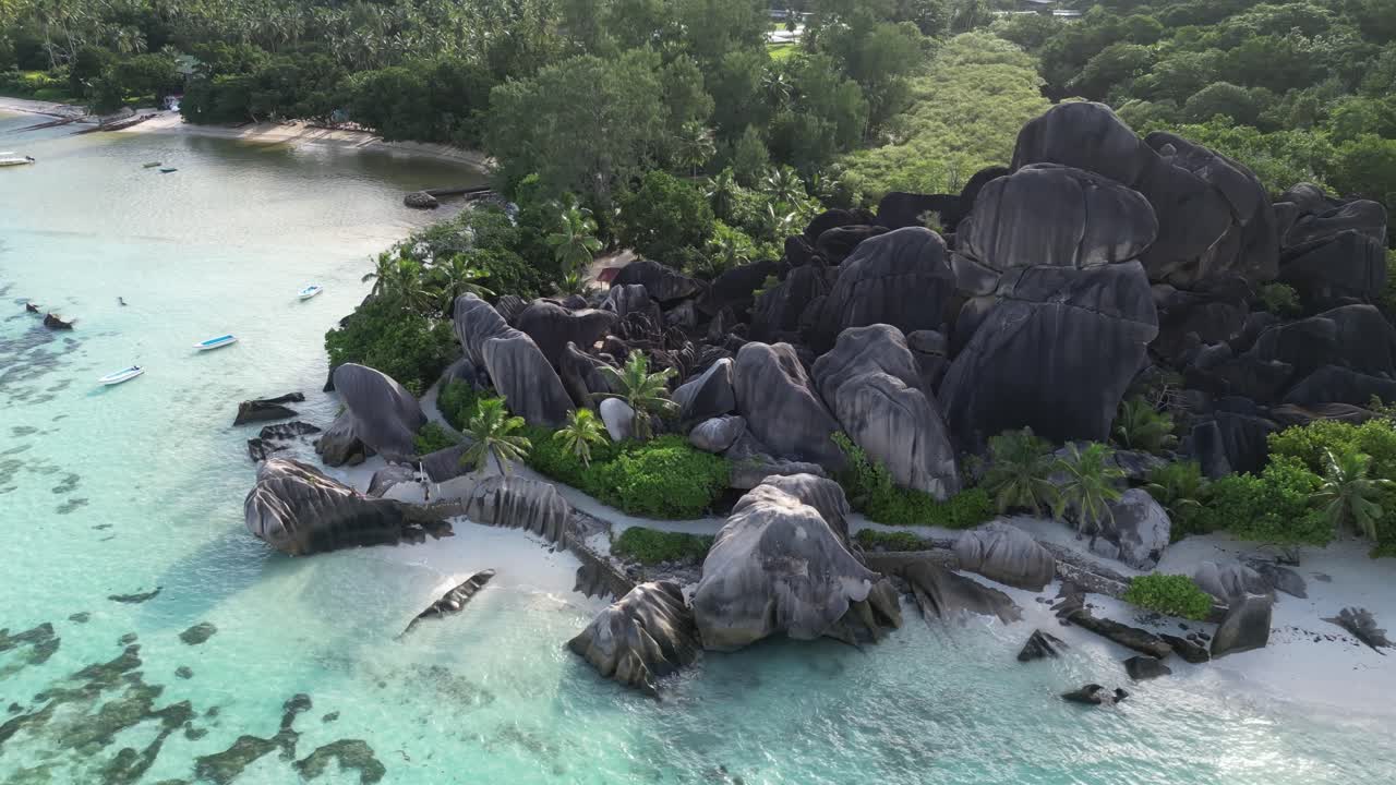 Isola di La Digue, Seychelles, drone aereo panoramico della costa di giorno che ruota attorno a una spiaggia tropicale isolata di sabbia bianca.