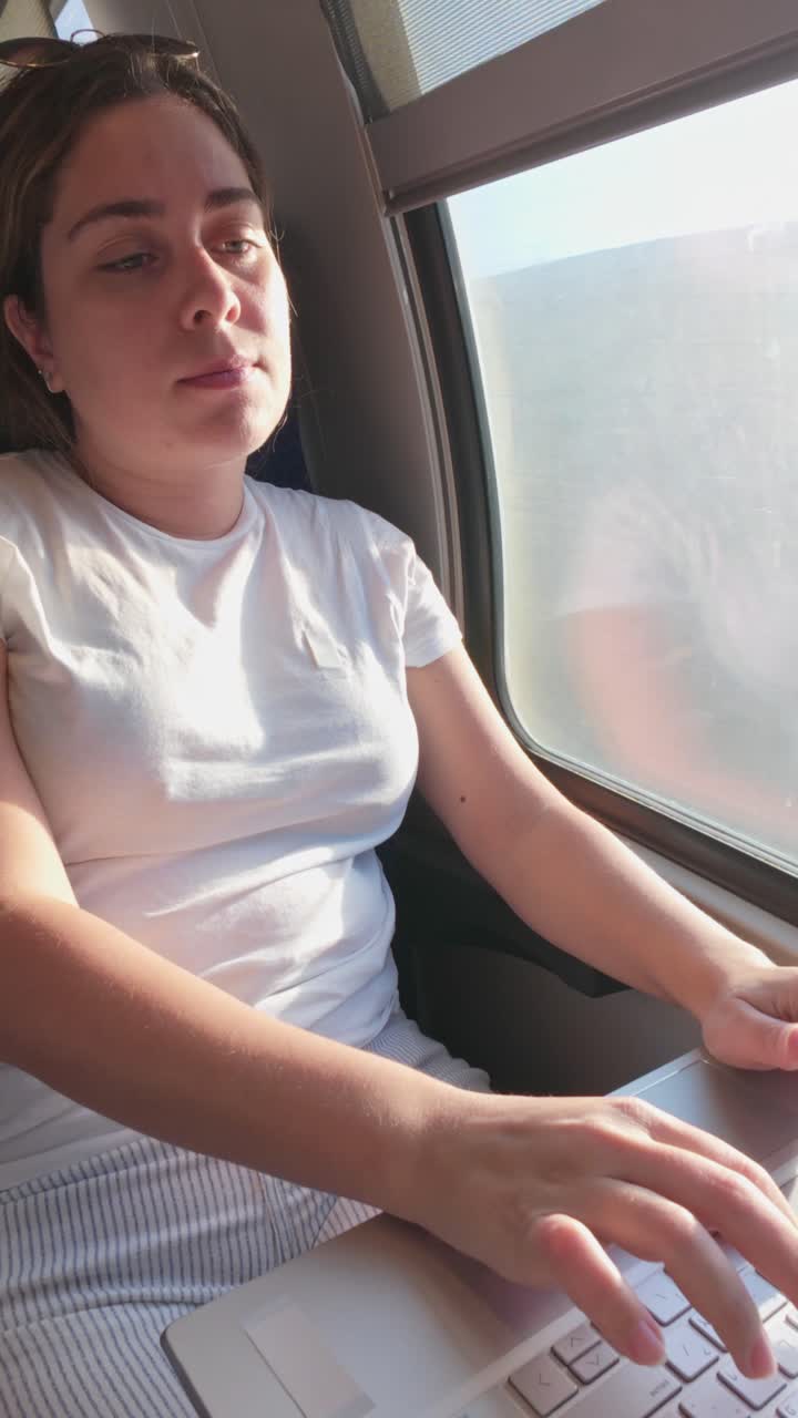 Close-up of a Woman Using Her Laptop Trackpad on a Train
