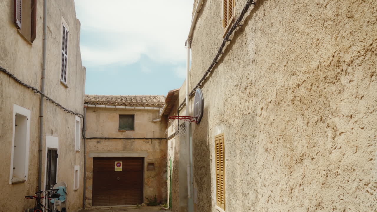 Rustic Mallorca alley with vintage basketball hoop. Captures European charm and outdoor sports passion. Perfect for travel vlogs or cultural documentaries.
