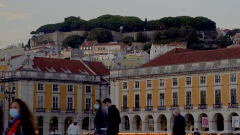 strolling in praça do comercio, lisbon, portugal. castelo de sao jorge in background. beautiful centenary buildings.