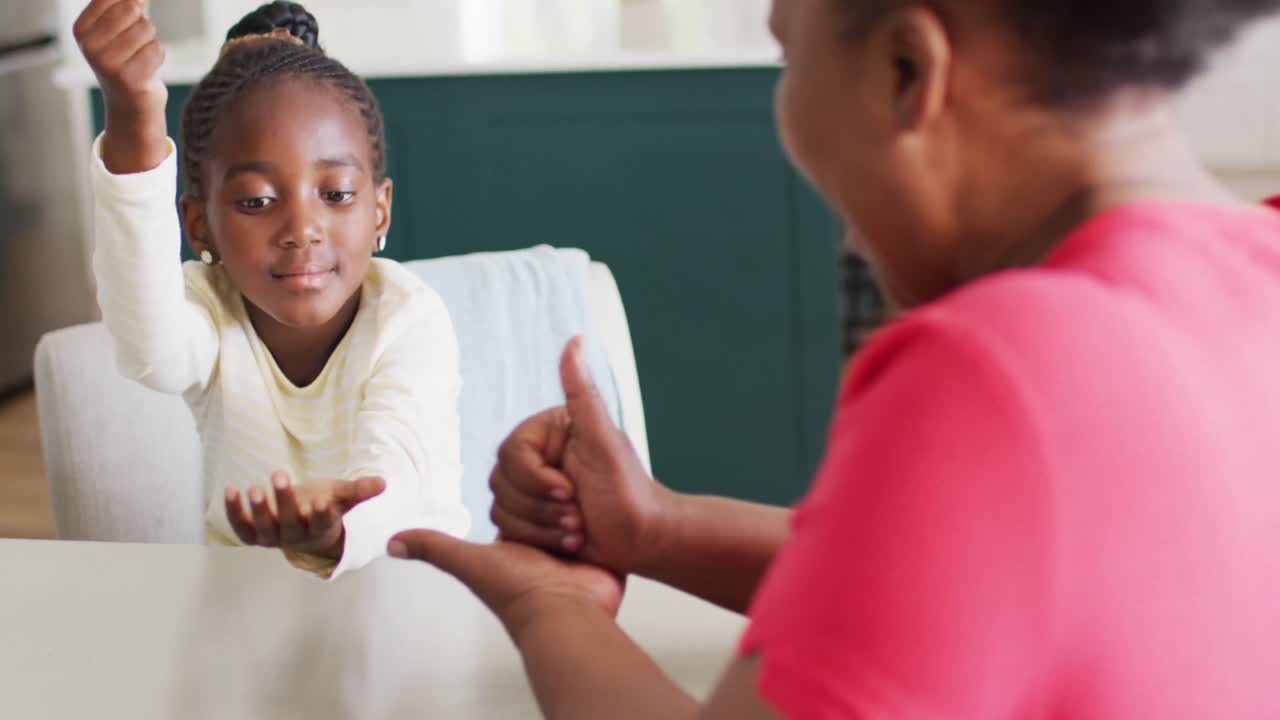 Video of smiling african american granddaughter using sign language with grandmother, copy space