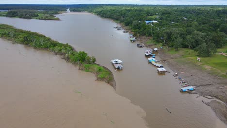 vista aérea en movimiento hacia adelante, muelles de barcos en la orilla del río amazonas en colombia