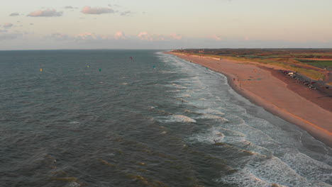 kitesurfers near the beach of domburg during sunset