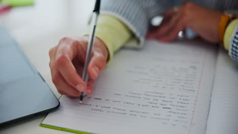 person writing notes on a notebook with a pen
