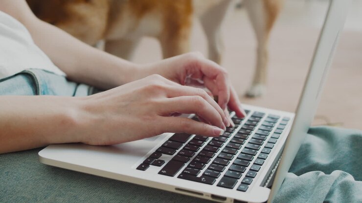 Le mani di una donna irriconoscibile digitano su una tastiera del computer.