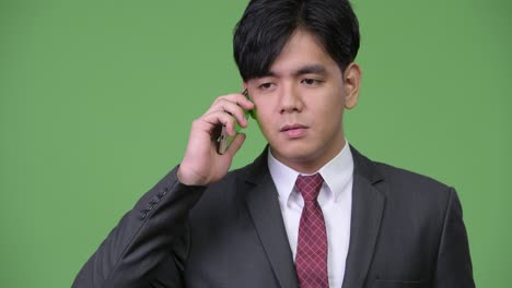 young handsome asian businessman using mobile phone