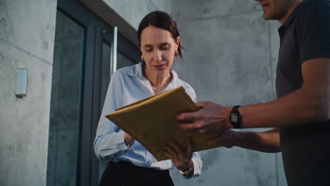 woman signing for a package delivered by a courier