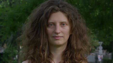 young woman staring at the camera showing neutral emotions but growing into uncomfortable