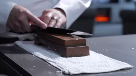 static left-side shot of a chef sharpening his knife, highlighting the skillful technique and focus on knife maintenance. perfect for cooking tutorials and culinary demonstrations.