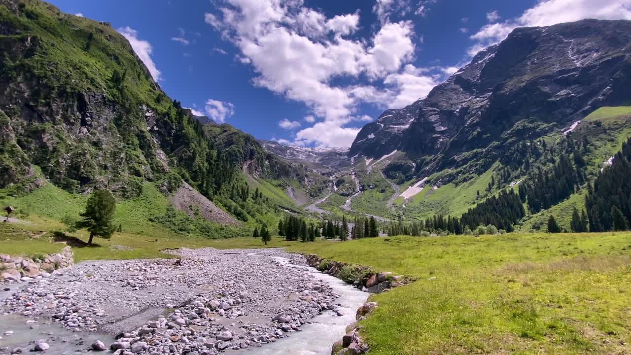 río con piedras en el hermoso valle de lüsens en austria con altas montañas y cielo azul en el fondo