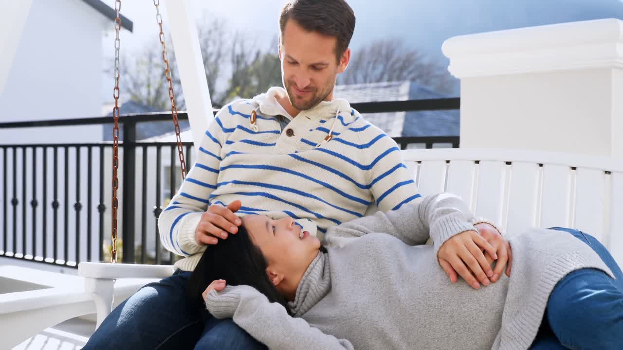ブランコでくつろぐ妊婦のカップル 4K