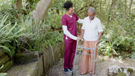 caregiver assisting senior woman with walker in peaceful garden setting