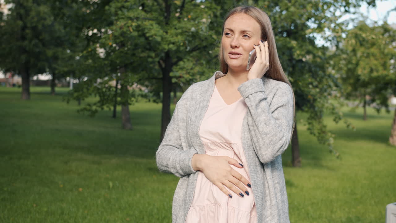 Pregnant Woman Talking on Phone in Park