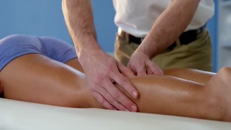 paciente femenina recibiendo masaje de piernas de un fisioterapeuta masculino