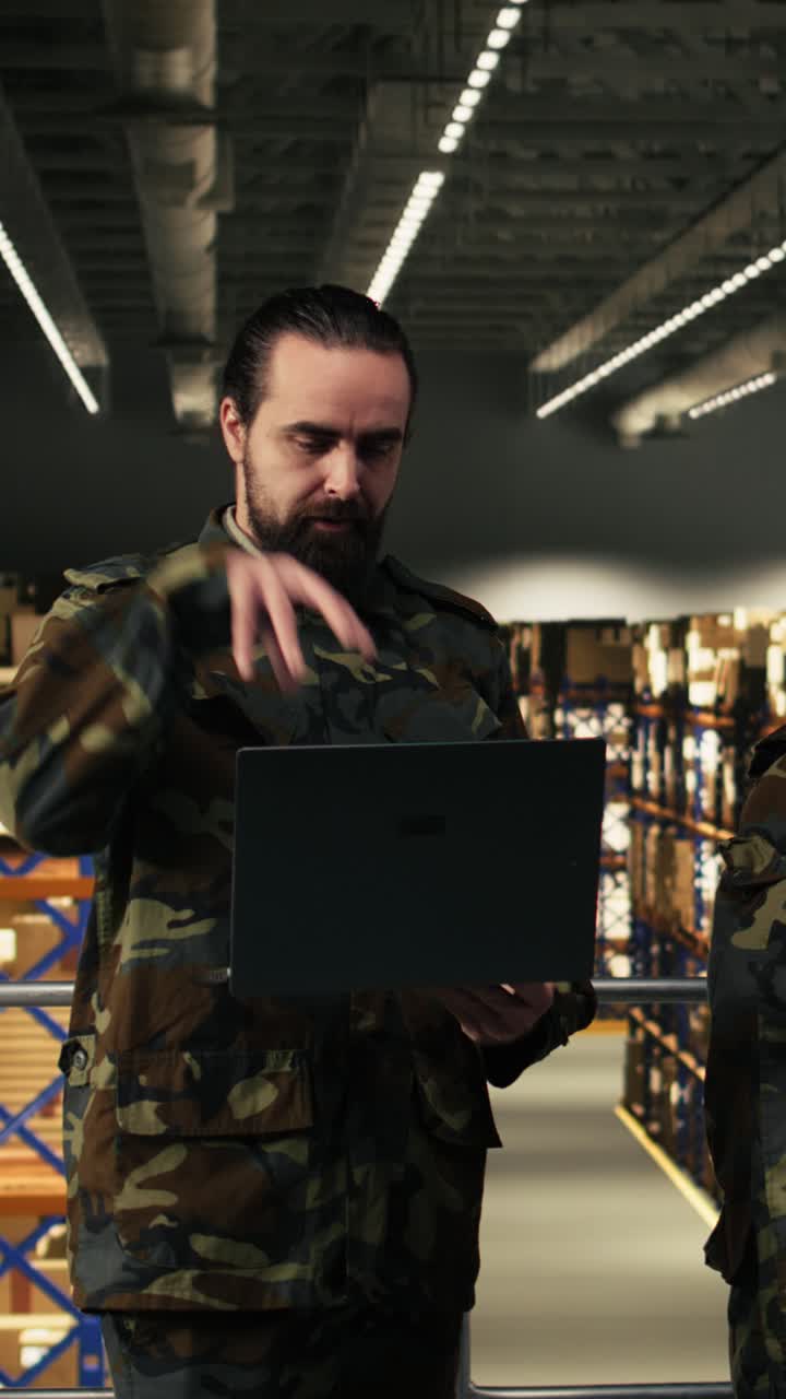 Vertical Video Black military personnel working on laptop in armed forces facility with cargo