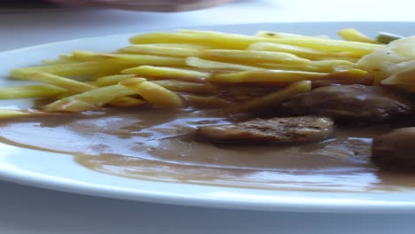 close up of a plate of swedish meatballs with mashed potatoes and fries