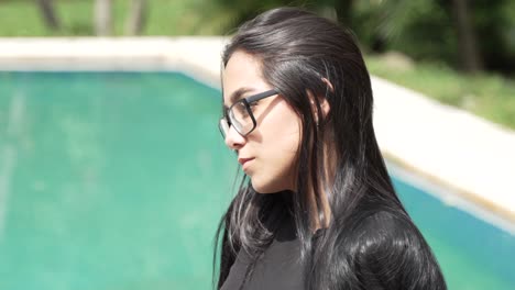 Hermosa-Mujer-Latina-De-Ojos-Verdes-Con-Gafas-Sentada-Junto-A-La-Piscina