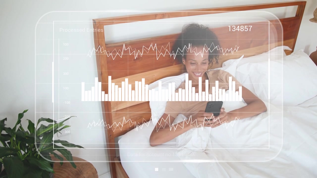 Woman reclining on bed tapping smartphone and activating HUD for checking finance charts 134857