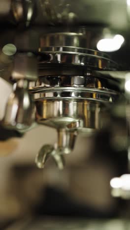 espresso machine brewing coffee into green cup