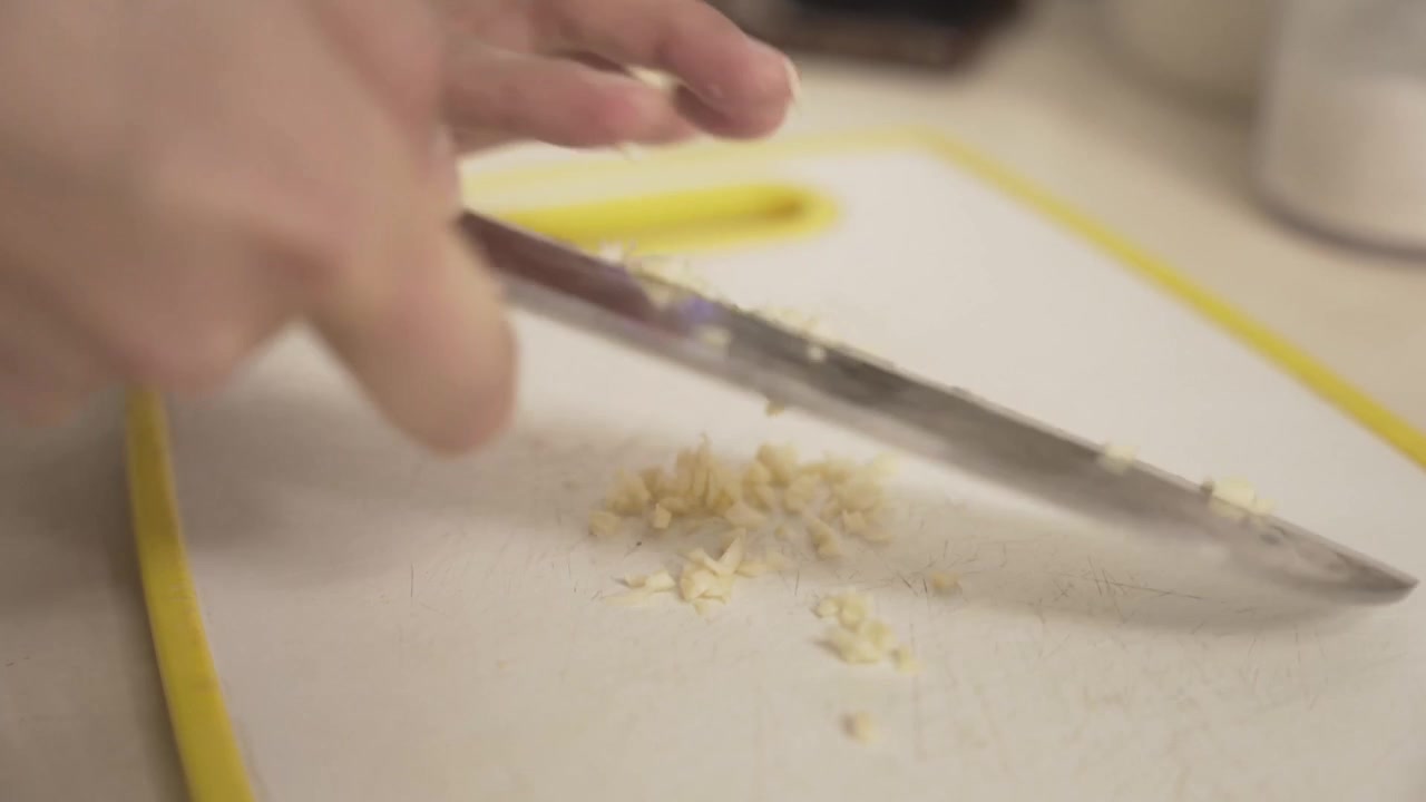 Close-up of female hands chopping garlic. Cooking, ingredients