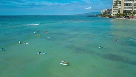 drone footage of surfers off the coast of waikiki beach, on the island of oahu, hawaii