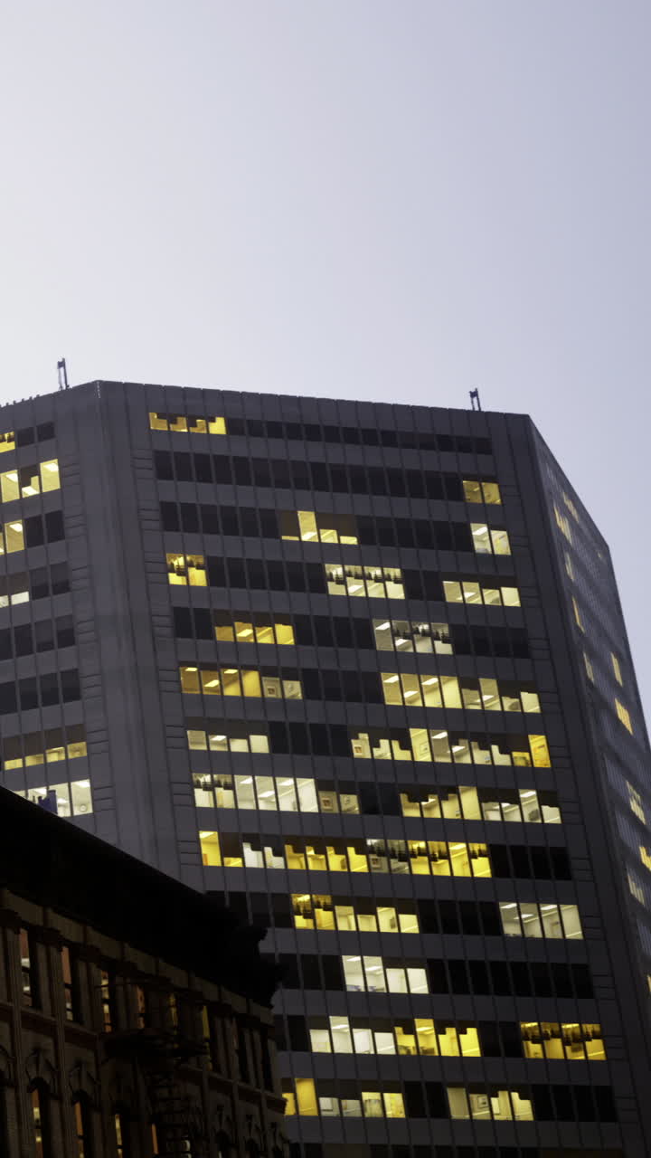 Edificios con luces encendidas en las ventanas durante las horas de la tarde en una ciudad