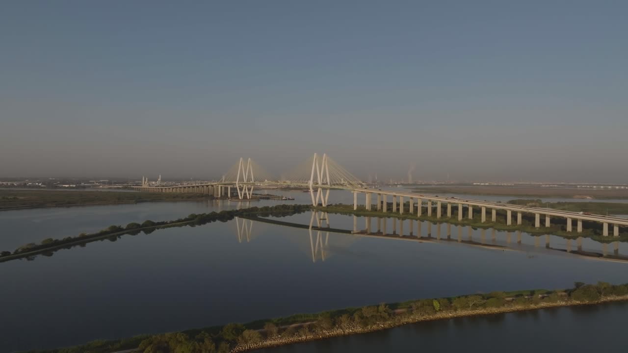 A 4K aerial drone view of the Fred Hartman Bridge, a cable-stayed structure spanning the Houston Ship Channel, located between the cities of Baytown and La Porte, southeast of Houston, Texas.