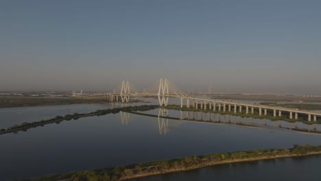 a 4k aerial drone view of the fred hartman bridge, a cable-stayed structure spanning the houston ship channel, located between the cities of baytown and la porte, southeast of houston, texas.