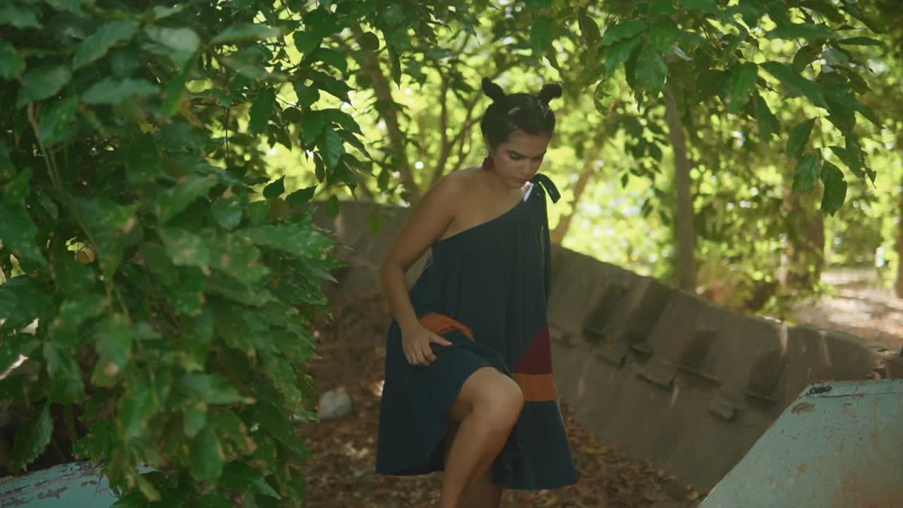 매혹적인 묘사는 한 젊은 아시아 모델이 한 어깨의 우아한 파란색 드레스로 우아하게 장식되어 장애물을 어렵지 않게 뛰어넘는 것을 보여줍니다.