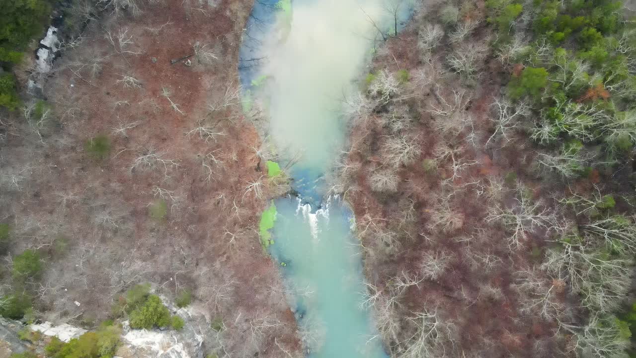 río de agua azul que fluye en un paisaje forestal de follaje colorido, aéreo