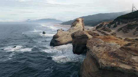 una toma de descenso lento que muestra la erosión causada por las olas que se estrellan en el cabo kiwanda