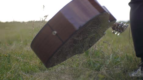 Man-in-a-black-suit-picking-up-a-guitare-from-the-ground