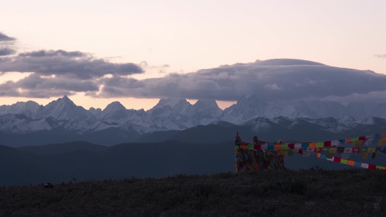 banderas de oración y el monte gongga cubierto de nubes al amanecer en yuzixi, sichuan, china