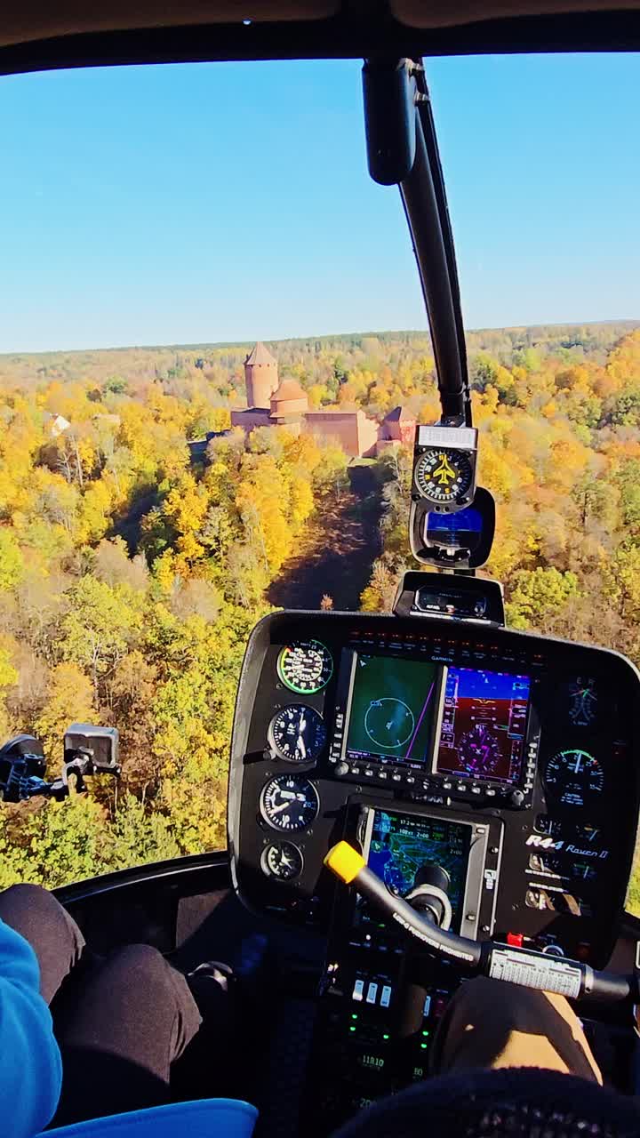 Low-altitude aerial view of vibrant autumn forest and historic Sigulda Castle