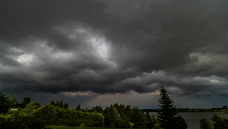 Lapso-De-Tiempo-De-Las-Nubes-De-Tormenta-Que-Se-Acumulan-Sobre-Los-árboles-Y-El-Lago