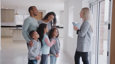 female realtor showing family interested in buying around house