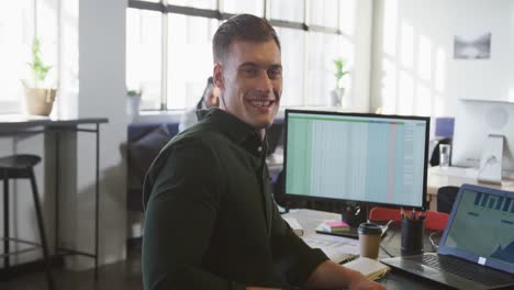 retrato de un feliz hombre de negocios caucásico mirando a la cámara en la oficina