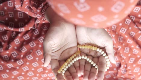 woman in prayer with prayer beads