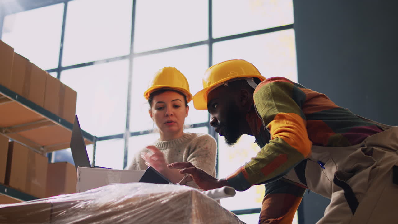 Warehouse workers checking inventory on laptop