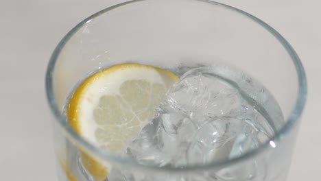 un vaso de agua con limón y hielo