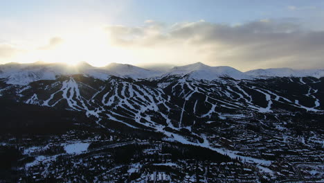 Aerial-Cinematic-drone-view-of-Breckenridge-Ski-area-and-town-from-Boreas-Pass-late-afternoon-sunset-over-mountain-tops-mid-winter-pan-to-the-right