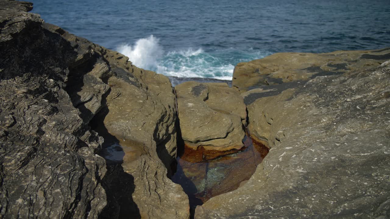 rocas costeras con olas oceánicas en el fondo - suburbios del este en sydney, nueva gales del sur, australia